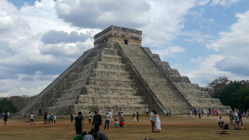 Touristes visitant Chichen Itza sous un ciel bleu